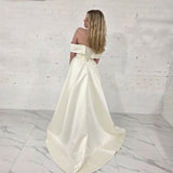 ivory A-line gown with sculpted draping, romantic sleeves, and timeless sophistication.