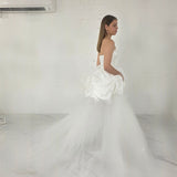 satin and tulle ballgown with cascading ribbons and romantic couture-inspired volume.