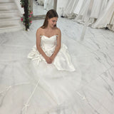 satin and tulle ballgown with cascading ribbons and romantic couture-inspired volume.