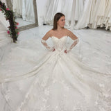 pearl-detailed lace ballgown with ethereal sleeves and regal bridal elegance.