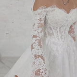 romantic lace ballgown wedding dress featuring off-shoulder sleeves, exposed boning, and timeless elegance