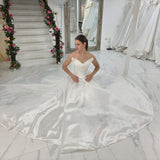 satin A-line wedding dress featuring a sculpted bodice, pearl waist detail, and timeless sophistication for hire