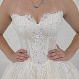 sparkling ivory lace wedding dress featuring a sweetheart neckline, corset back, and romantic ballgown silhouette