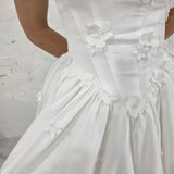 romantic satin wedding dress featuring a drop waist, 3D floral details, and timeless elegance for hire
