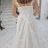 white A-line wedding dress featuring floral beaded lace, Chantilly lace, a basque waist, and corset elegance.