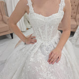 white A-line wedding dress featuring floral beaded lace, Chantilly lace, a basque waist, and corset elegance.