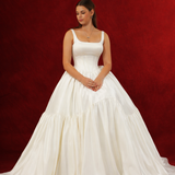 white wedding ballgown with straight neckline, basque waist, corset back, and layered skirt.