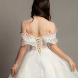 White wedding dress with asymmetrical bustier top and puffy layered skirt