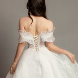 White wedding dress with asymmetrical bustier top and puffy layered skirt