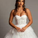 White wedding dress with a bushier top and a bushier puffy layered skirt