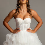 White wedding dress with a bushier top and a bushier puffy layered skirt