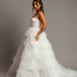 White wedding dress with a bushier top and a bushier puffy layered skirt