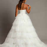 White wedding dress with a bushier top and a bushier puffy layered skirt