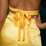 Yellow satin column shaped dress with ribbed corset look and a high slit