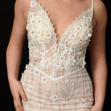 Ethereal ivory and white gown with floral embellishments and a dramatic thigh-high slit.
