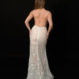 Ethereal ivory and white gown with floral embellishments and a dramatic thigh-high slit.