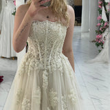 romantic white and cream A-line wedding dress with elegant floral pearl detailing
