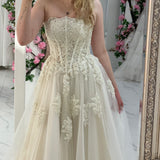 romantic white and cream A-line wedding dress with elegant floral pearl detailing