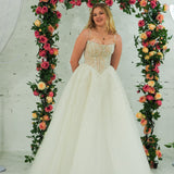 white wedding ballgown featuring a straight neckline, delicate beaded straps, sheer sparkling bodice, basque waistline, and corset back.