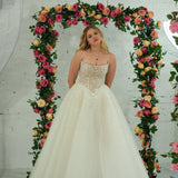 white wedding ballgown featuring a straight neckline, delicate beaded straps, sheer sparkling bodice, basque waistline, and corset back.