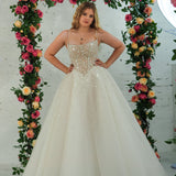 white wedding ballgown featuring a straight neckline, delicate beaded straps, sheer sparkling bodice, basque waistline, and corset back.