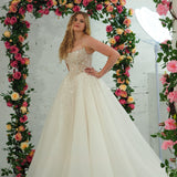 white wedding ballgown featuring a straight neckline, delicate beaded straps, sheer sparkling bodice, basque waistline, and corset back.