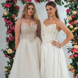 white wedding ballgown featuring a straight neckline, delicate beaded straps, sheer sparkling bodice, basque waistline, and corset back.