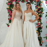 white wedding ballgown featuring a straight neckline, delicate beaded straps, sheer sparkling bodice, basque waistline, and corset back.