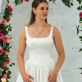 white wedding ballgown with straight neckline, basque waist, corset back, and layered skirt for hire