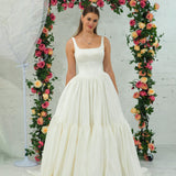 white wedding ballgown with straight neckline, basque waist, corset back, and layered skirt for hire