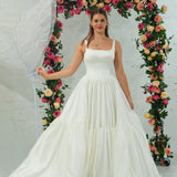 white wedding ballgown with straight neckline, basque waist, corset back, and layered skirt.