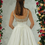white wedding ballgown with straight neckline, basque waist, corset back, and layered skirt for hire