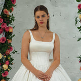 white wedding ballgown with straight neckline, basque waist, corset back, and layered skirt for hire