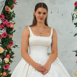 white wedding ballgown with straight neckline, basque waist, corset back, and layered skirt for hire