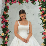 white wedding ballgown with straight neckline, basque waist, corset back, and layered skirt for hire