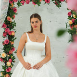white wedding ballgown with straight neckline, basque waist, corset back, and layered skirt for hire