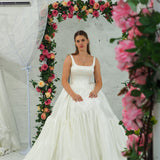 white wedding ballgown with straight neckline, basque waist, corset back, and layered skirt for hire