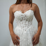 A-line gown with corseted structure and floral sparkle.