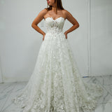 A-line gown with corseted structure and floral sparkle.
