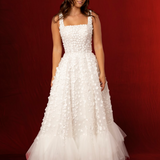Romantic A-line gown with 3D florals, glittered mesh, and soft tulle layers.