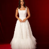 Romantic A-line gown with 3D florals, glittered mesh, and soft tulle layers.