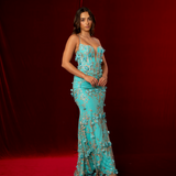 turquoise mermaid gown with plunging V neckline, exposed corset boning, and gold glitter floral appliqué.