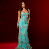 turquoise mermaid gown with plunging V neckline, exposed corset boning, and gold glitter floral appliqué.