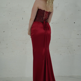 Dazzling red mermaid gown featuring a beaded corset bodice, thigh-high slit, and elegant train.