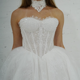 ballgown wedding dress featuring sparkling lace, dramatic hips, and an elegant neck cuff for hire
