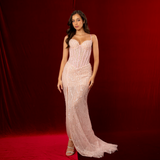 A baby pink mermaid formal gown with sweetheart neckline, exposed corset boning, beaded mesh, and elegant slit.