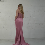 Dazzling baby pink mermaid gown featuring a beaded corset bodice, thigh-high slit, and elegant train.