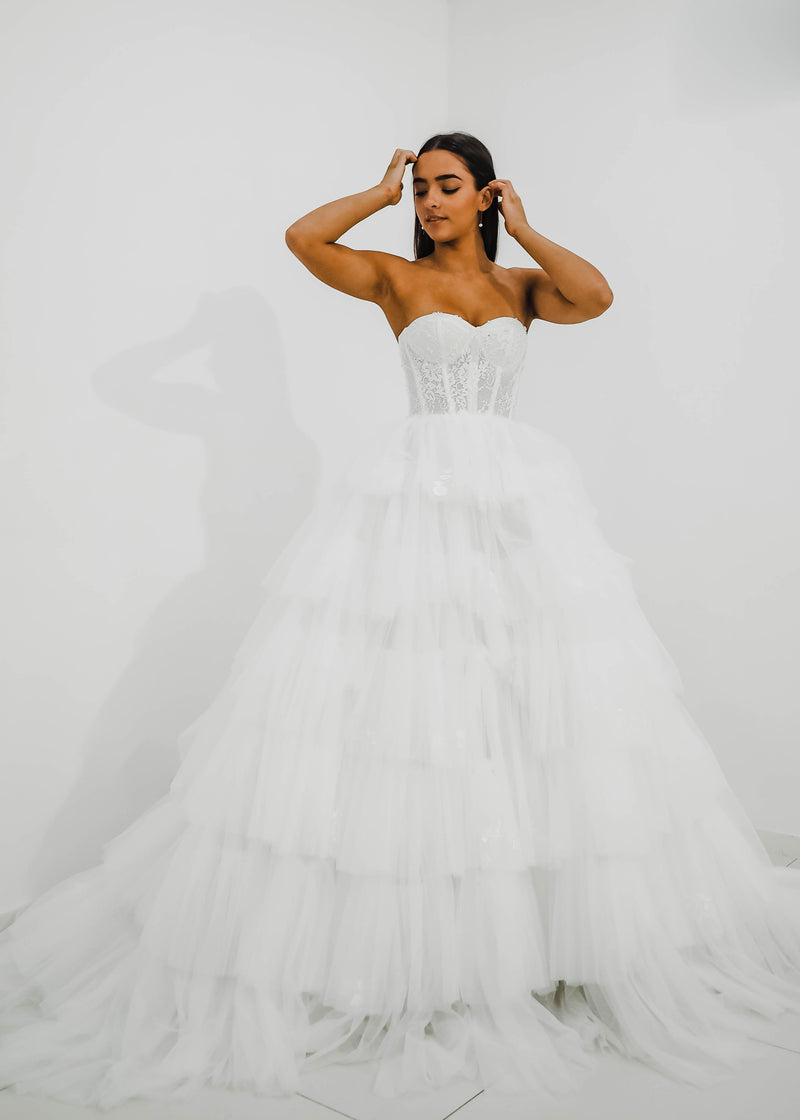 Rina white wedding dress with a bushier top and a bushier puffy layered skirt